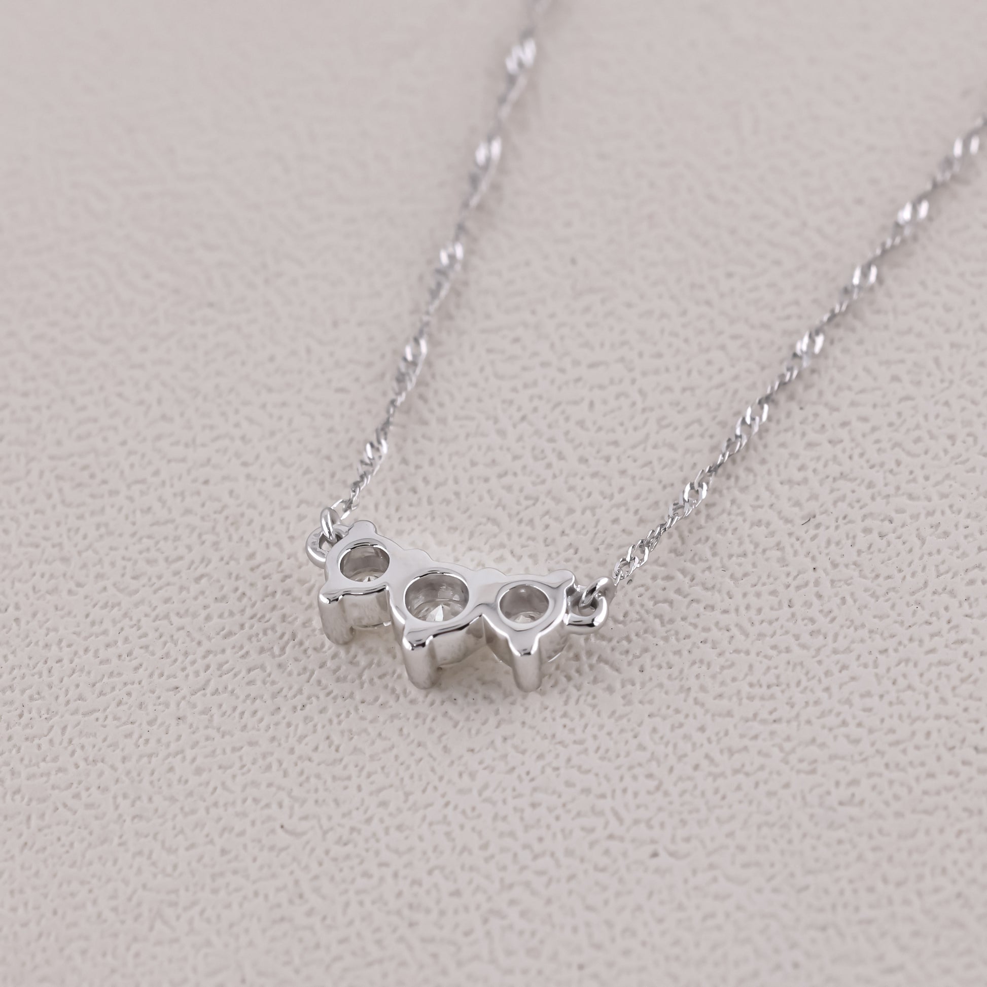 Silver knuckle duster necklace on a light gray background