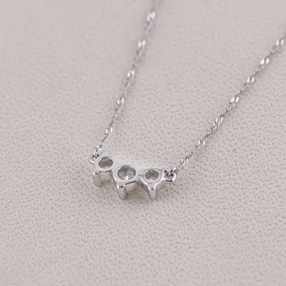 Silver knuckle duster necklace on a light gray background