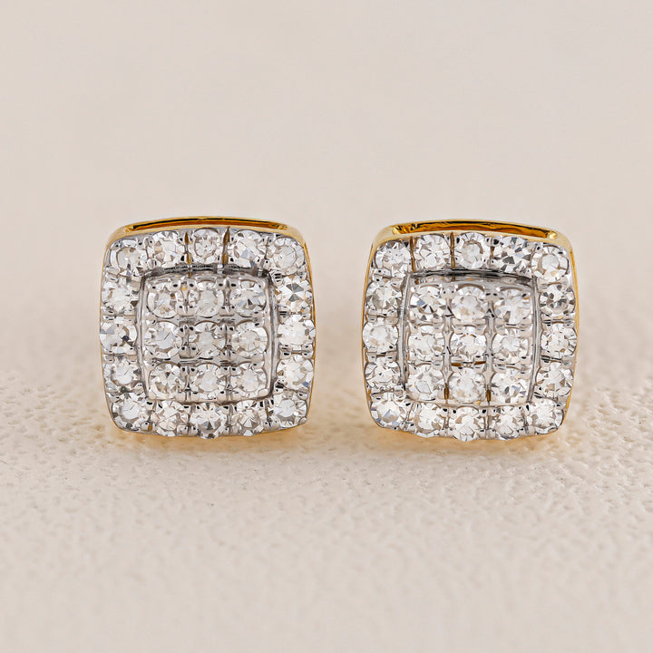 Pair of diamond earrings on a beige background