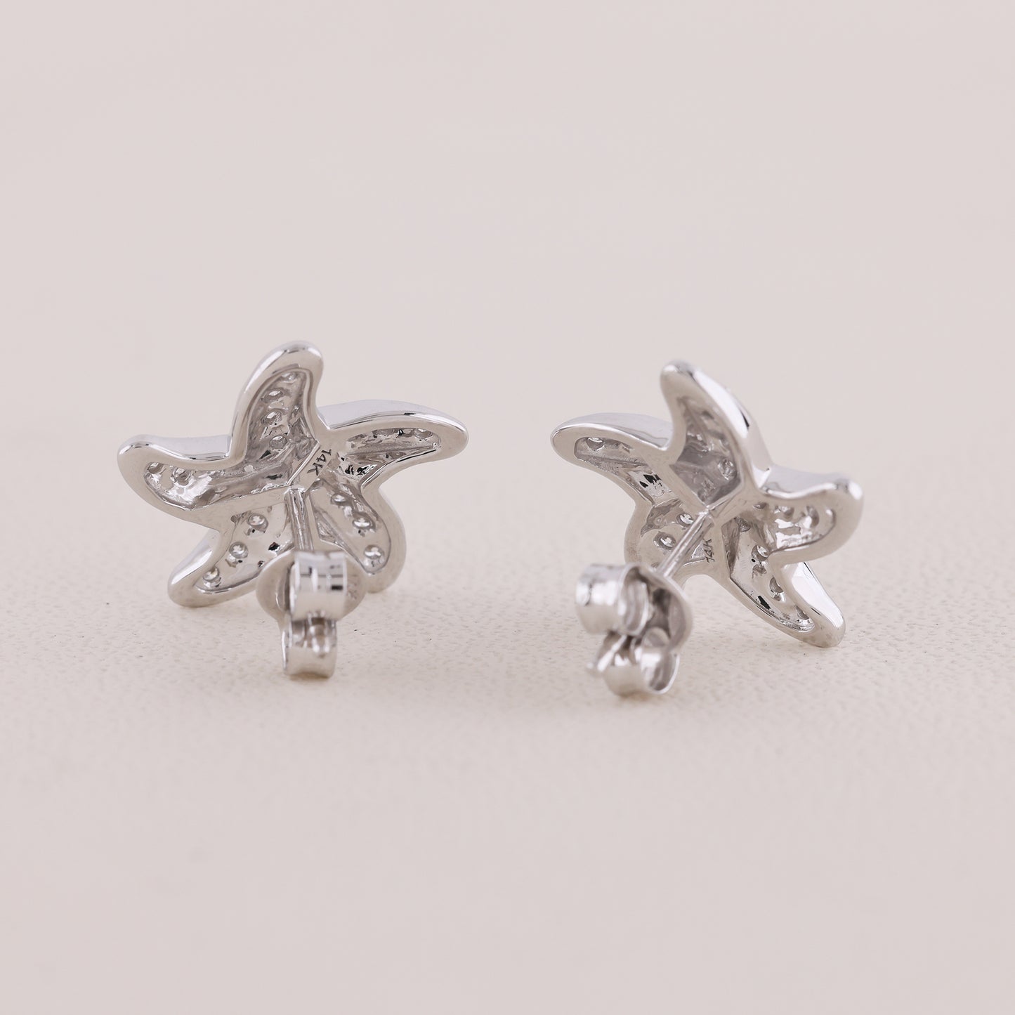 Butterfly-shaped silver earrings on a light gray background