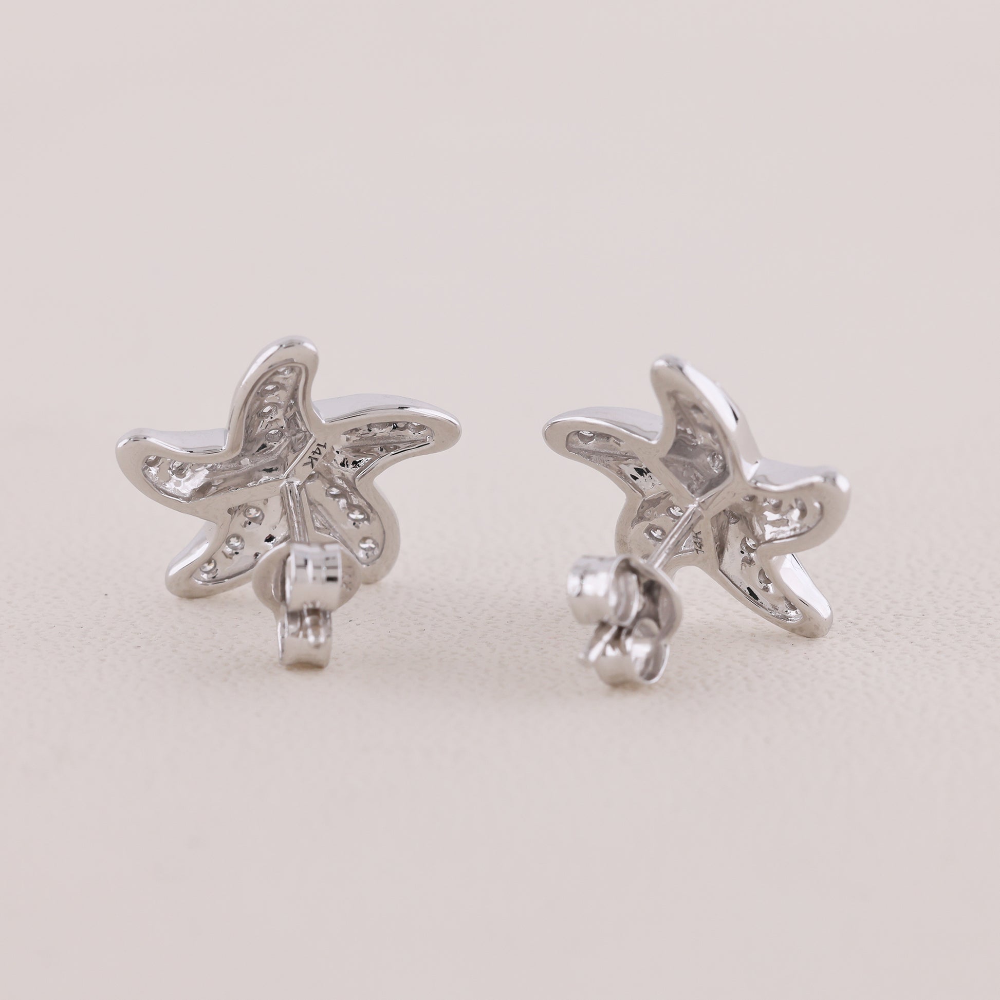 Butterfly-shaped silver earrings on a light gray background