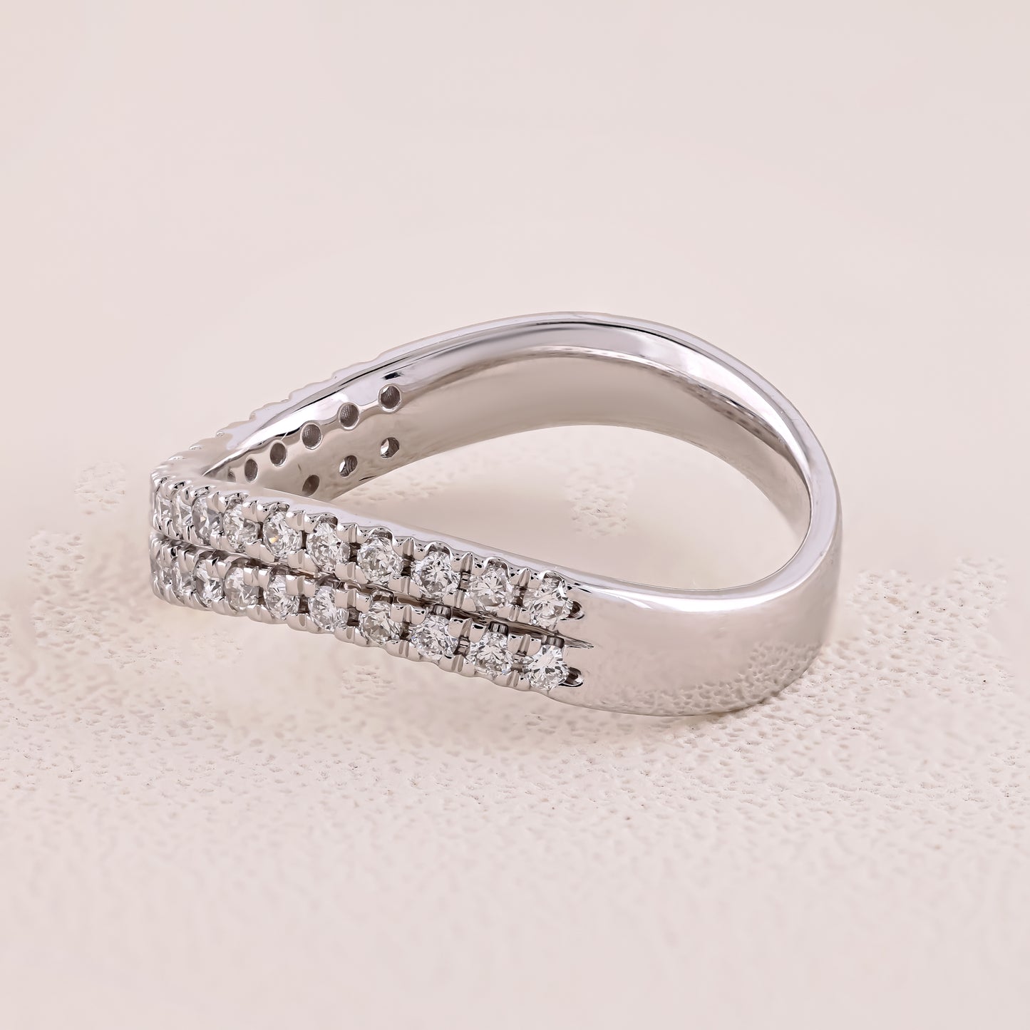 Silver ring with diamond accents on a beige background