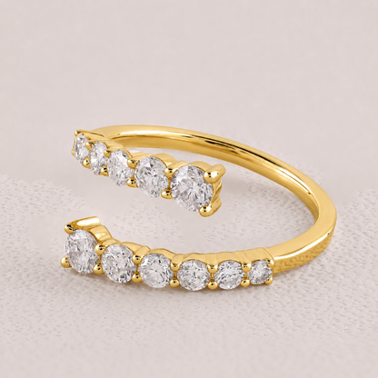 Gold open toe ring with clear gemstones on a light beige background