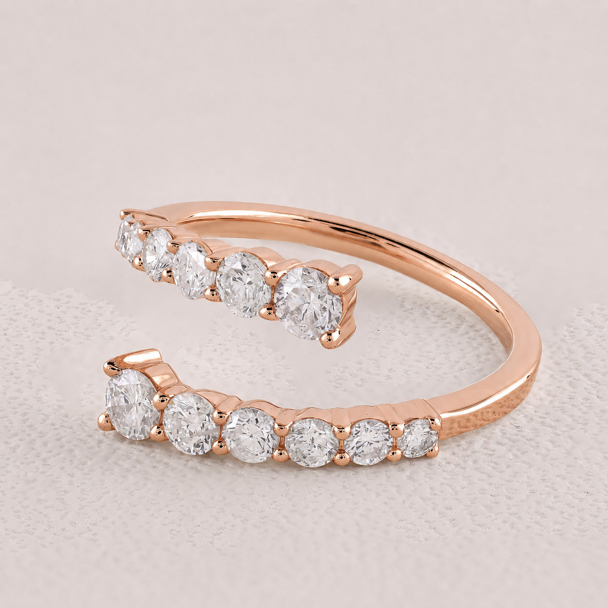 Rose gold ring with clear gemstones on a light gray background