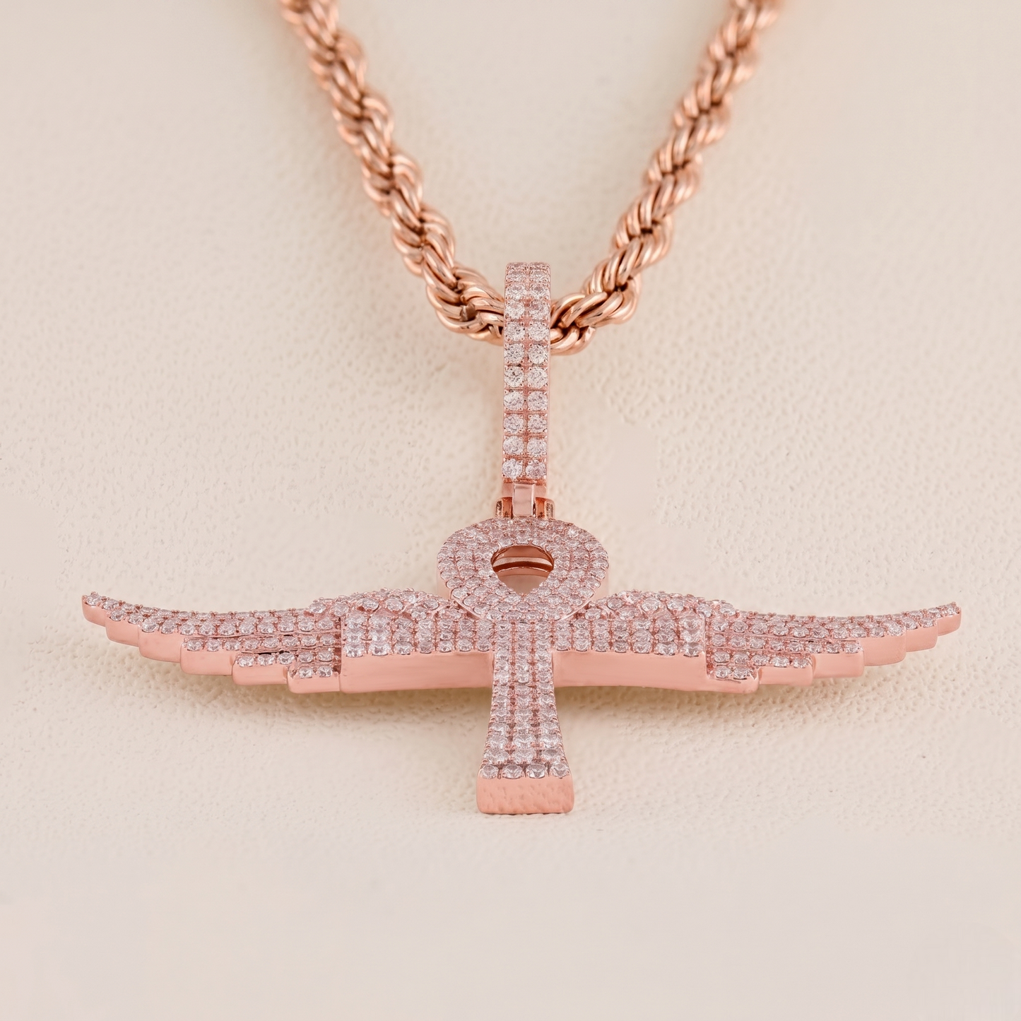 Rose gold necklace with a cross pendant on a beige background