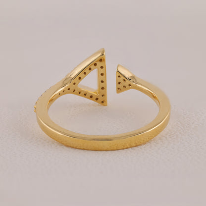 Gold open ring with geometric design on a light beige background