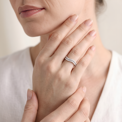 Close-up of a woman's hand wearing a diamond ring with a soft background