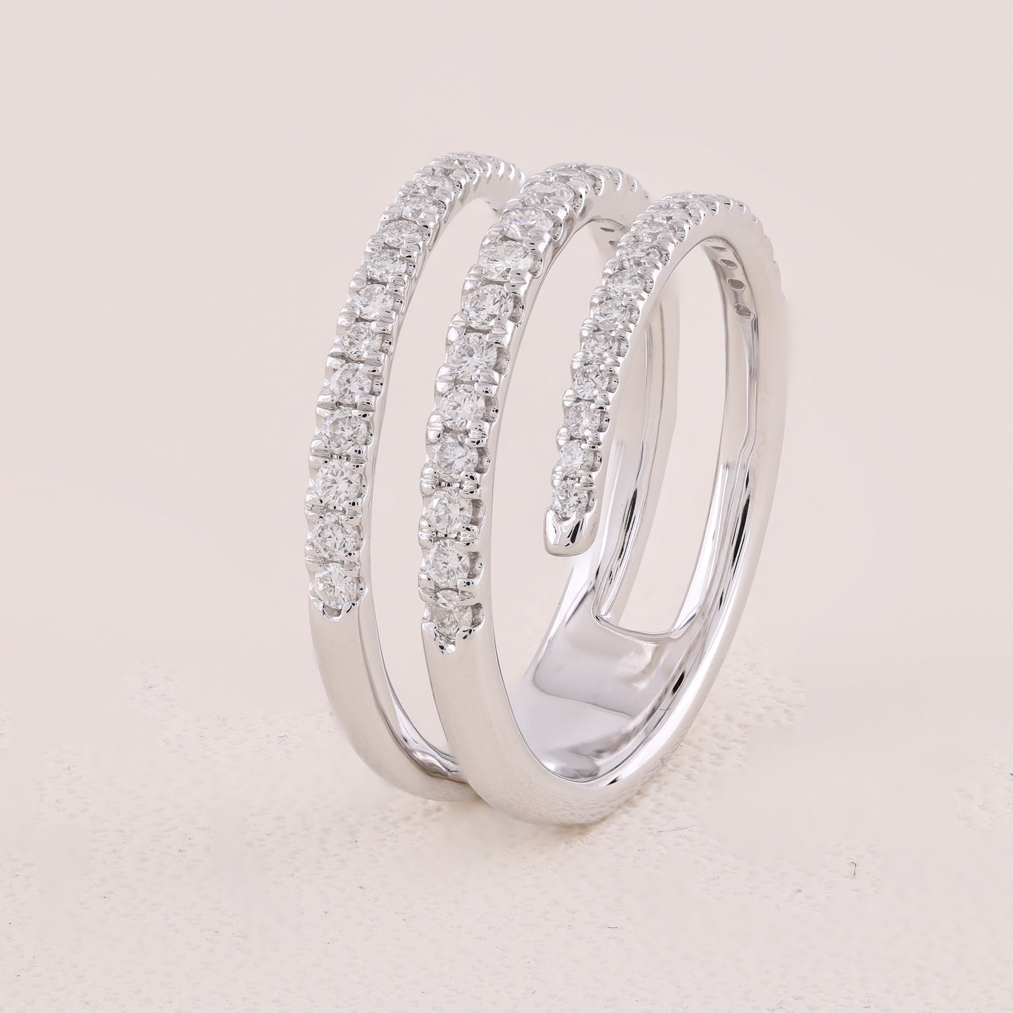 Silver ring with diamond accents on a light beige background