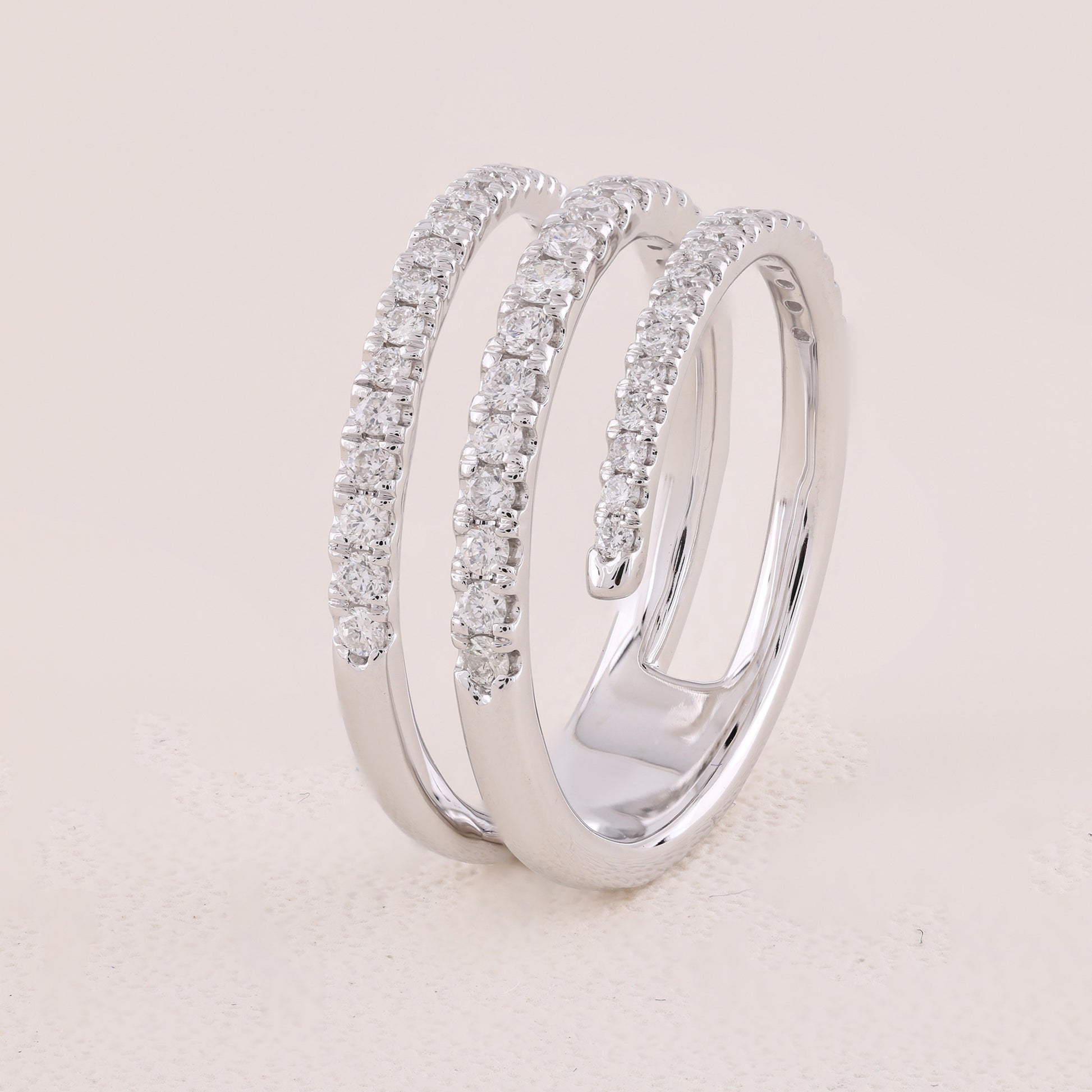 Silver ring with diamond accents on a light beige background