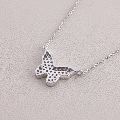 Silver butterfly necklace on a light gray background