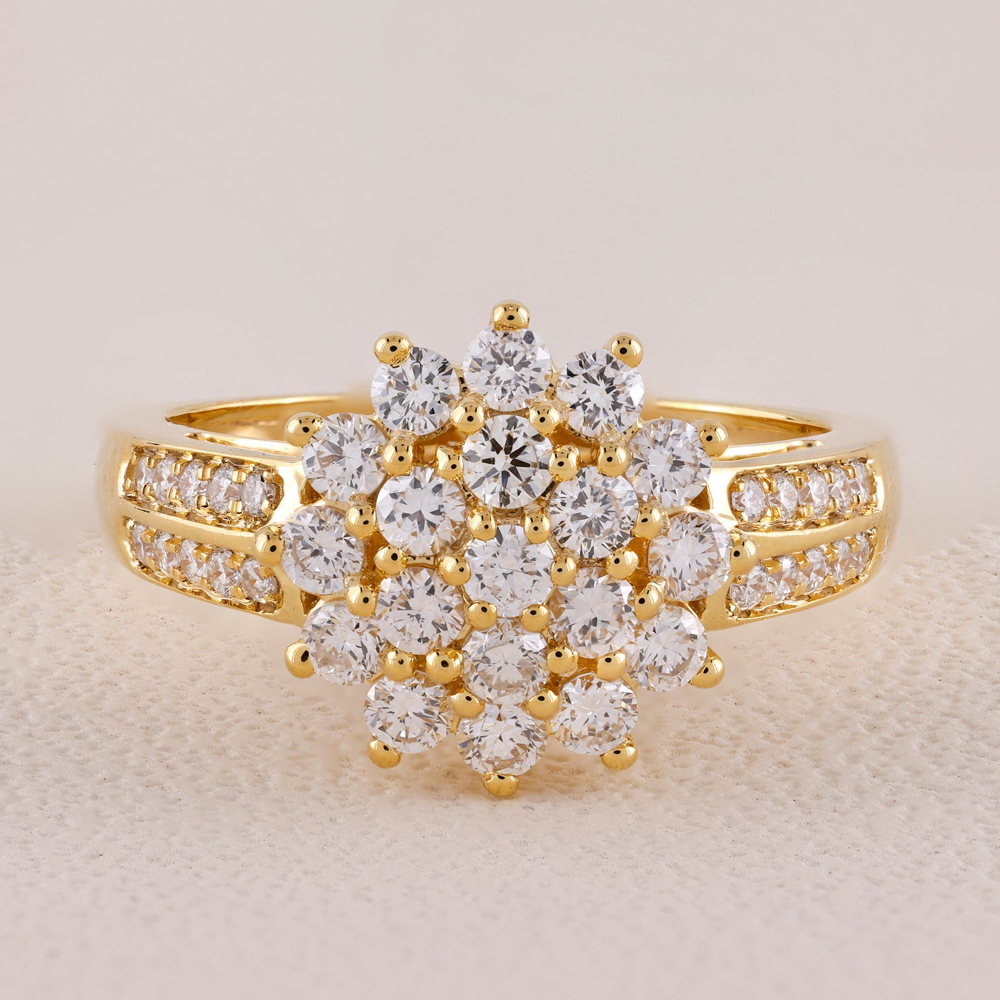Gold ring with diamond cluster on a light background