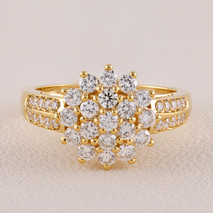 Gold ring with diamond cluster on a light background