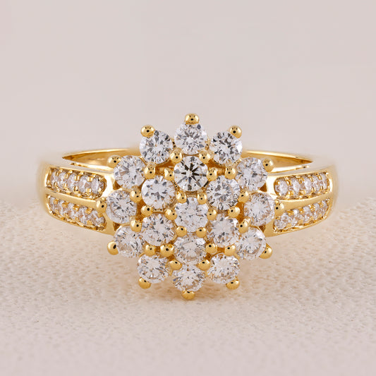 Gold ring with diamond cluster on a light background