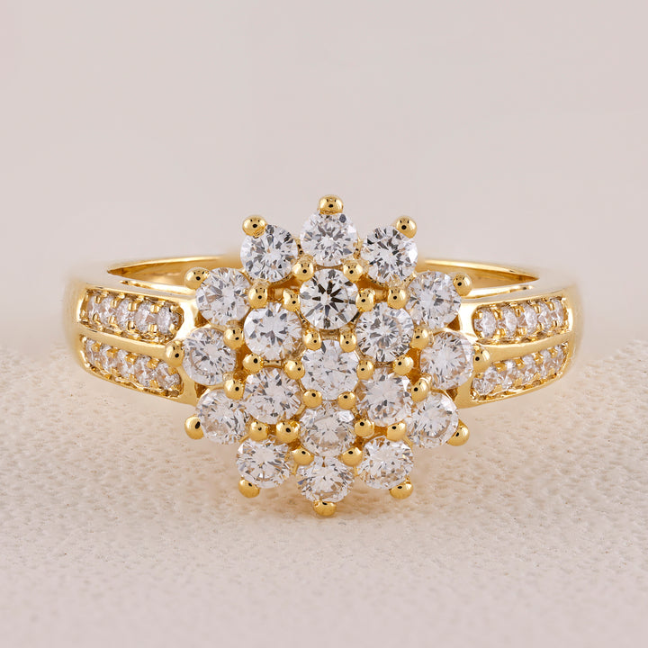 Gold ring with diamond cluster on a light background