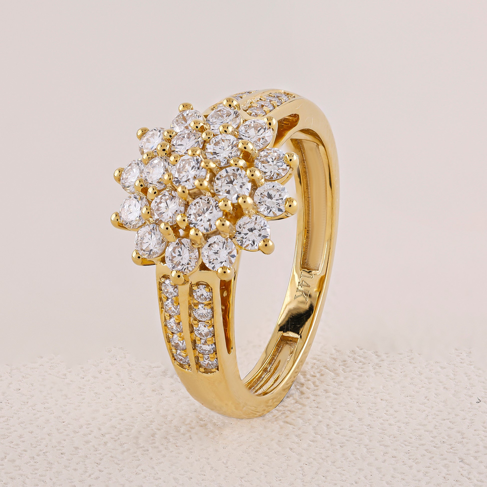 Gold ring with diamond cluster on a light gray background