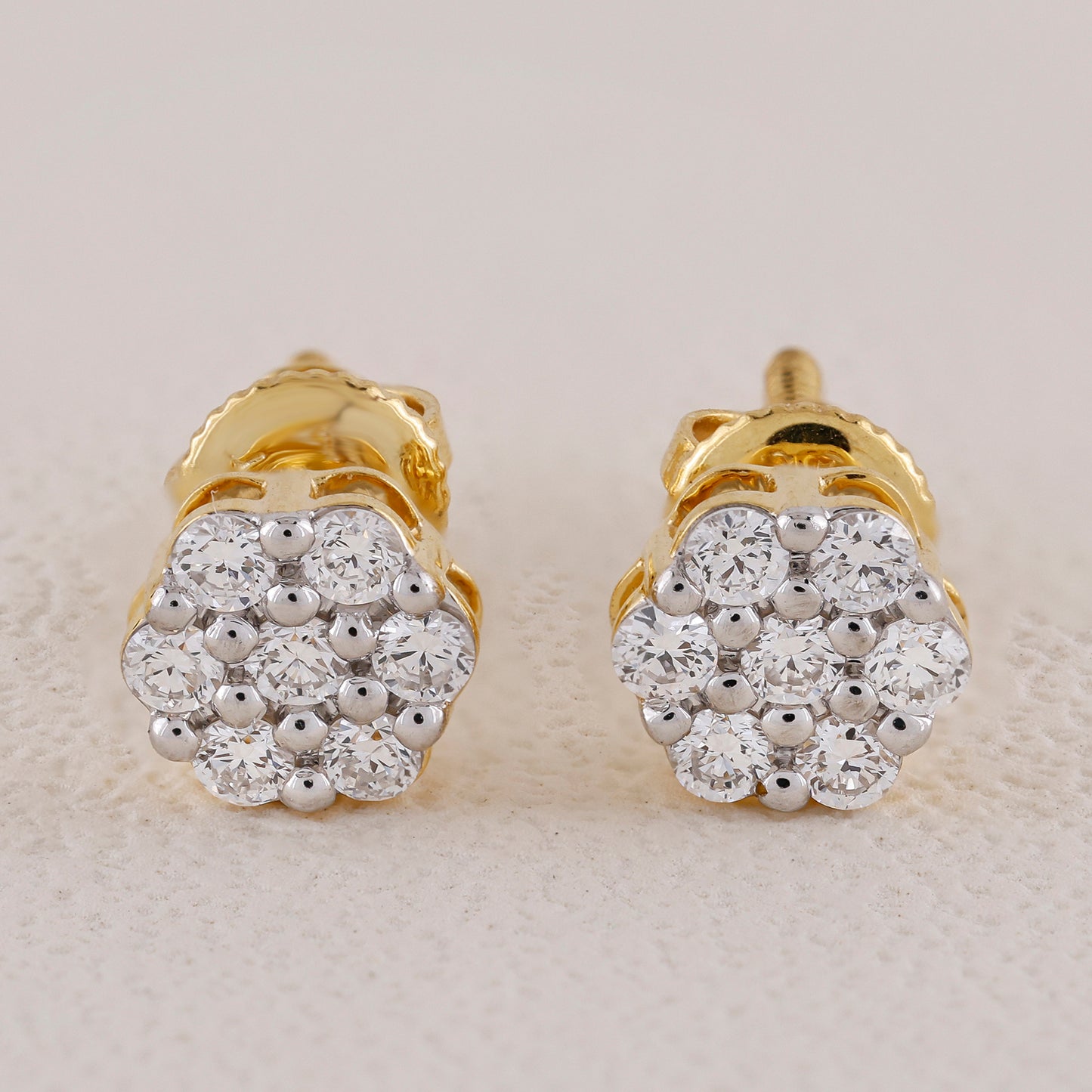 Pair of gold and diamond earrings on a light background