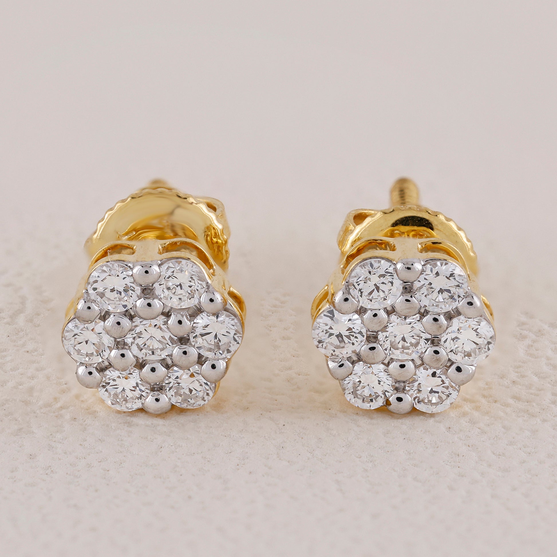 Pair of gold and diamond earrings on a light background