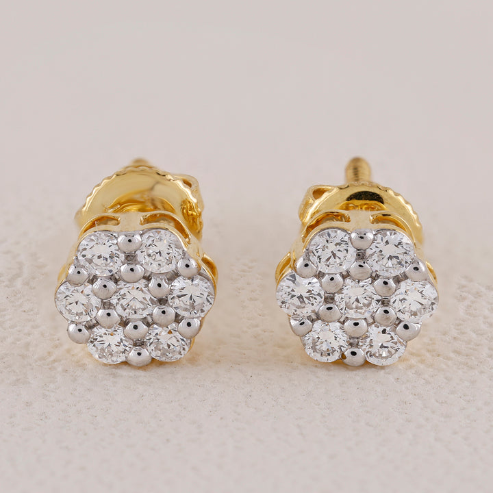 Pair of gold and diamond earrings on a light background