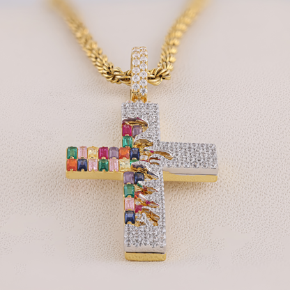 Gold cross pendant with colorful gemstones on a light background