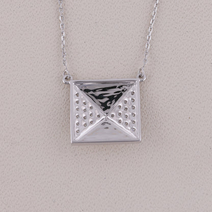 Silver geometric pendant necklace on a light gray background