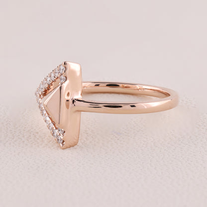 Rose gold ring with diamond accents on a light beige background