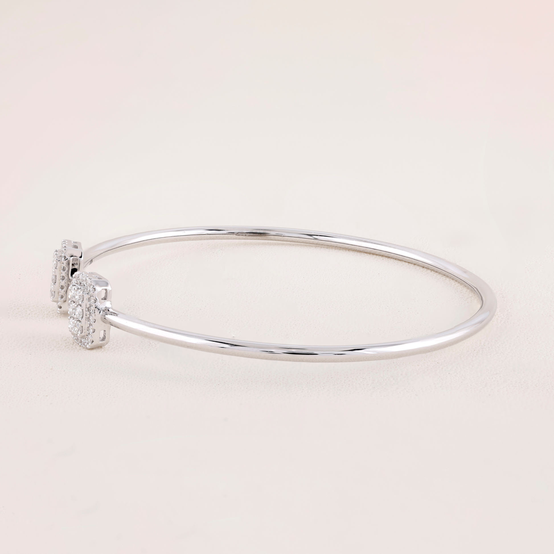 Silver bracelet with small diamonds on a light pink background