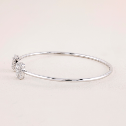 Silver bracelet with small diamonds on a light pink background