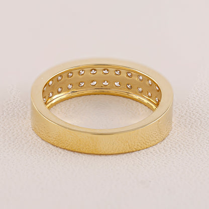 Gold ring with diamond accents on a light beige background