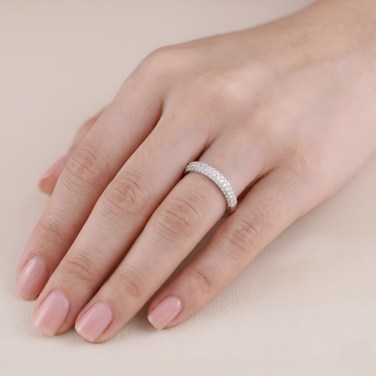 Silver ring on a hand with a soft beige background