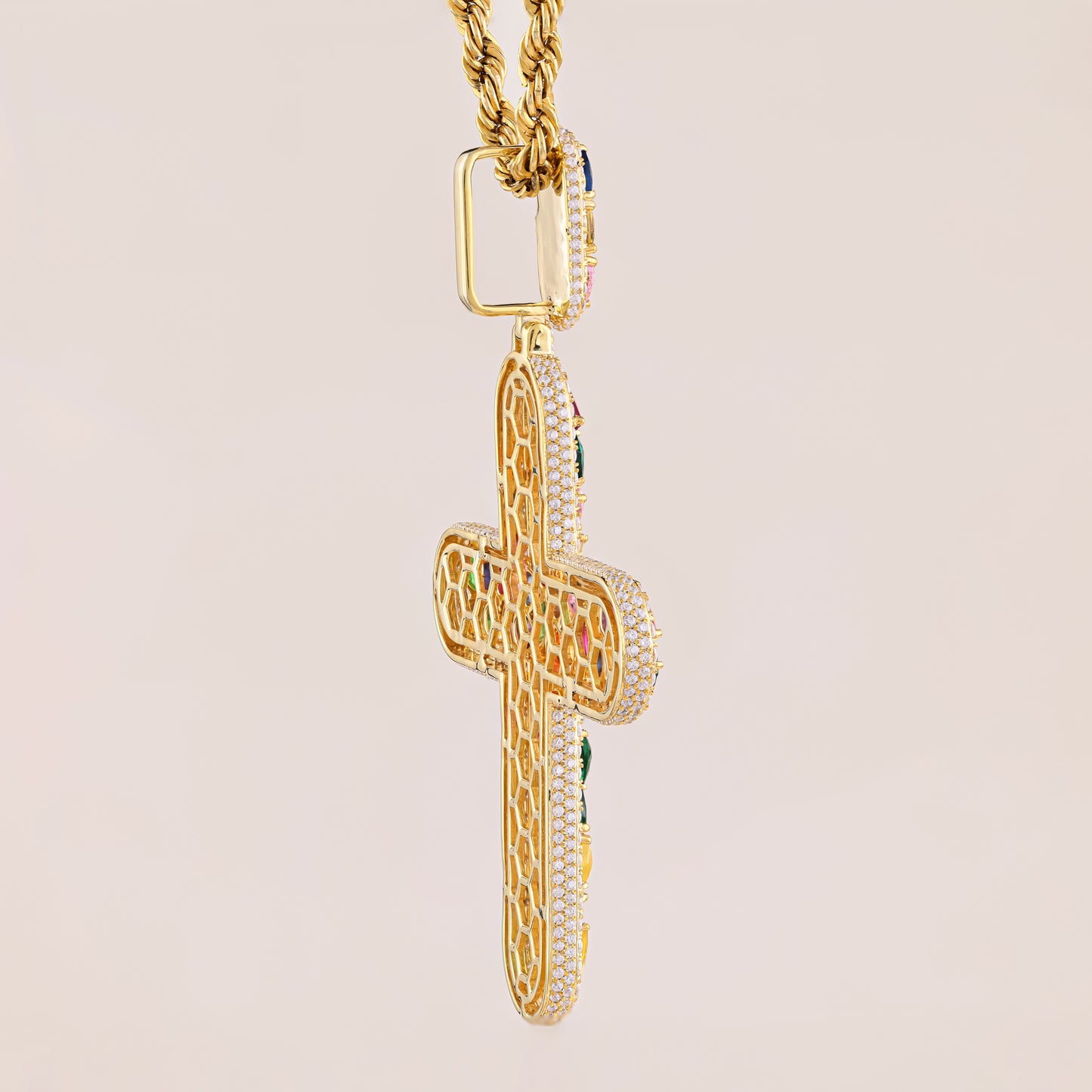 Gold cross pendant with intricate designs on a beige background