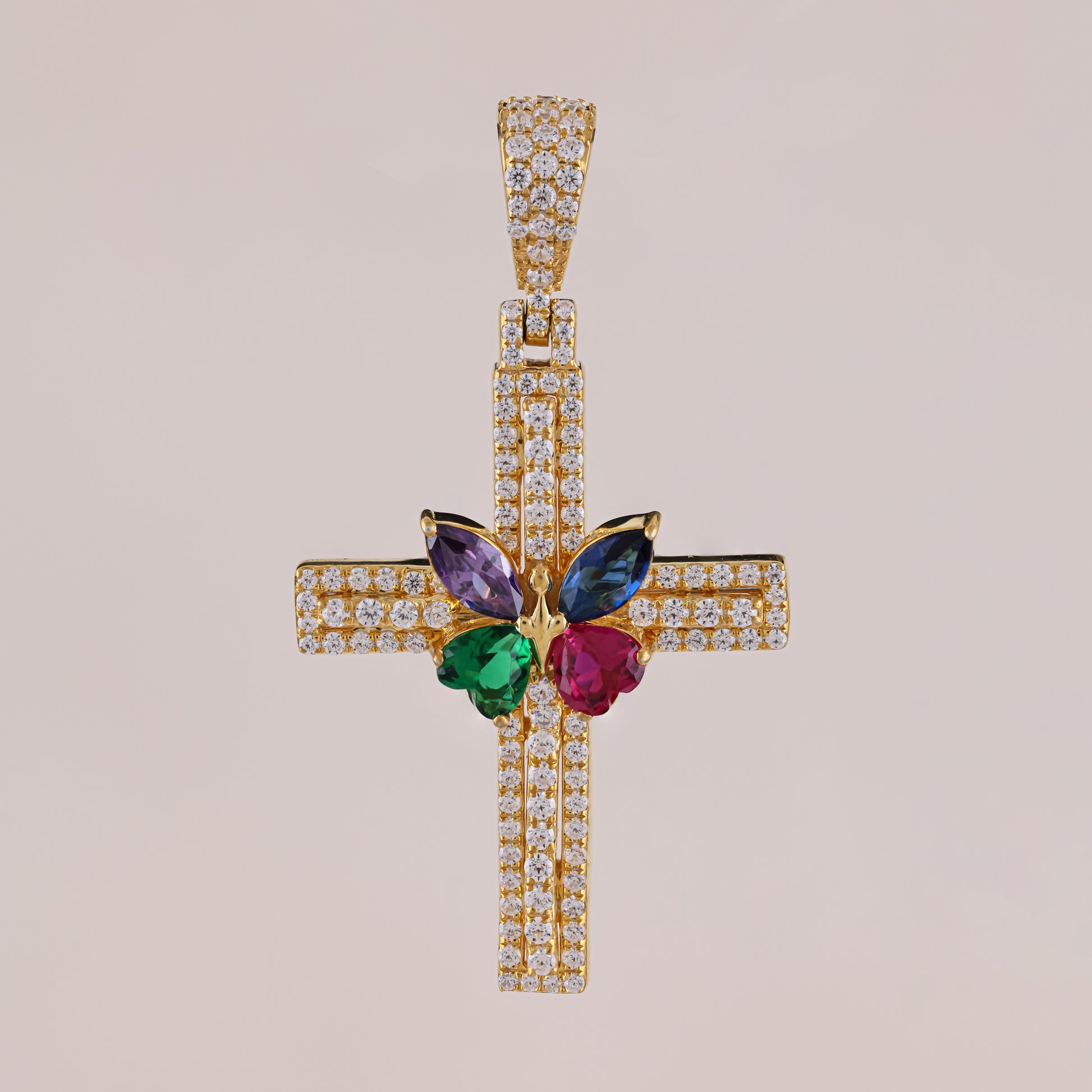 Gold cross pendant with colorful gemstones on a beige background