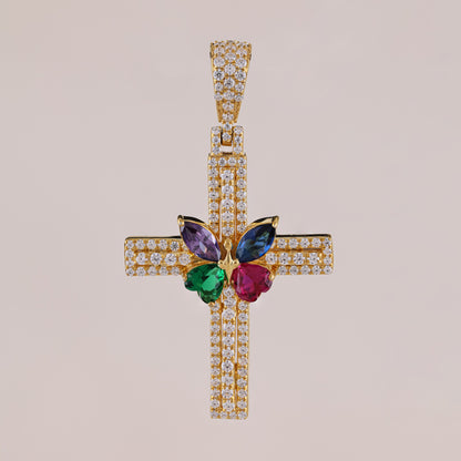 Gold cross pendant with colorful gemstones on a beige background