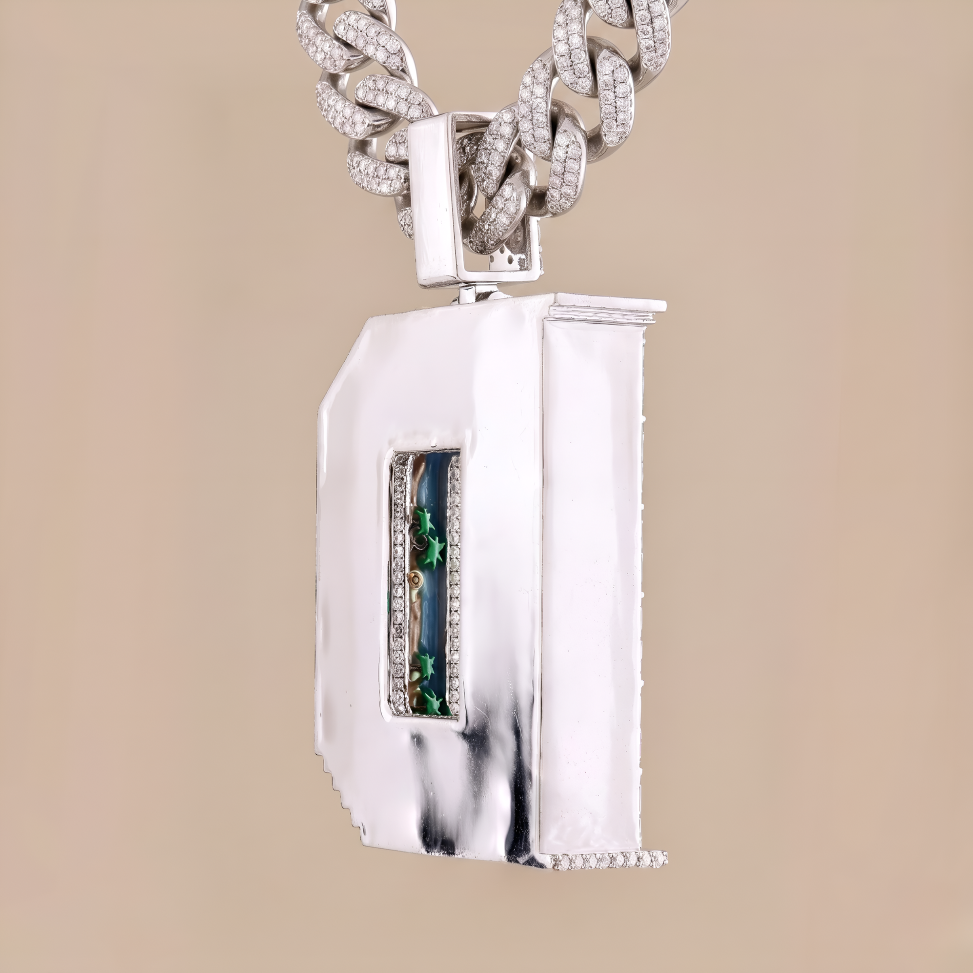 Silver necklace with a rectangular pendant featuring green gemstones on a beige background