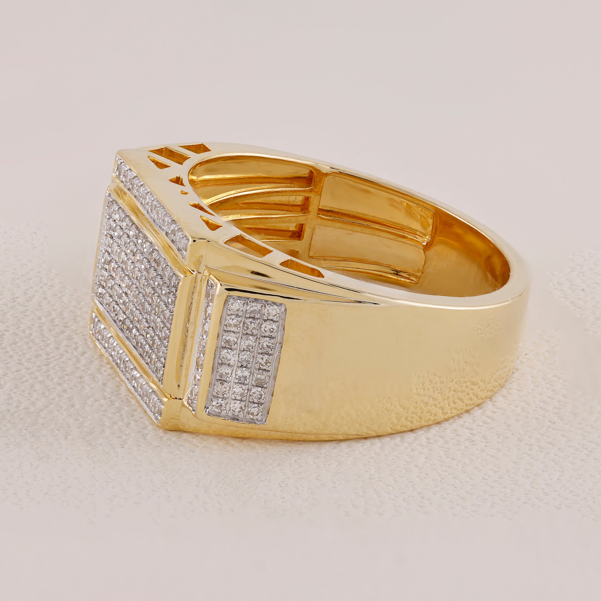 Gold ring with diamond accents on a light gray background