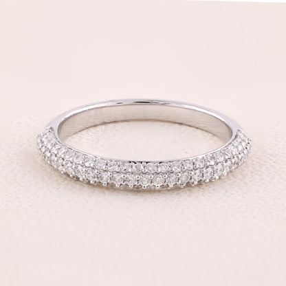 Silver ring with small diamonds on a light pink background