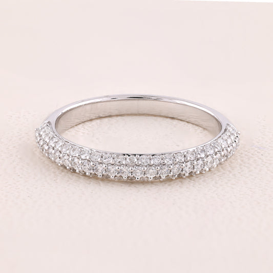 Silver ring with small diamonds on a light pink background
