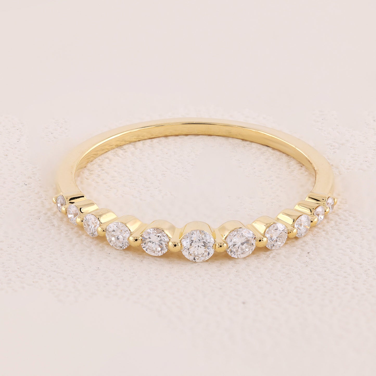 Gold ring with diamonds on a light pink background