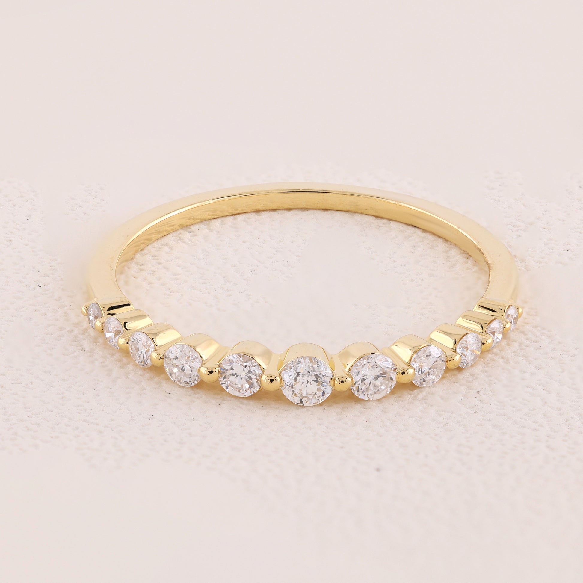 Gold ring with diamonds on a light pink background