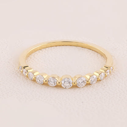 Gold ring with diamonds on a light pink background