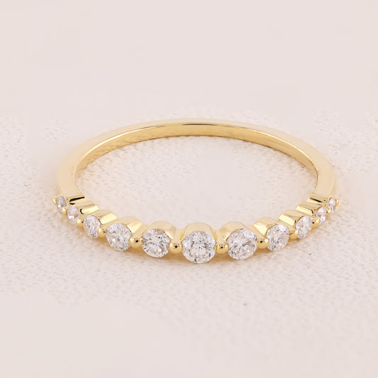 Gold ring with diamonds on a light pink background
