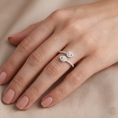 Silver ring with floral design on a hand against a beige background