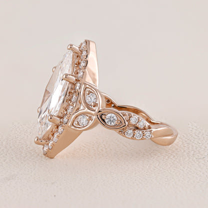 Rose gold ring with a large diamond and smaller diamonds on a light background
