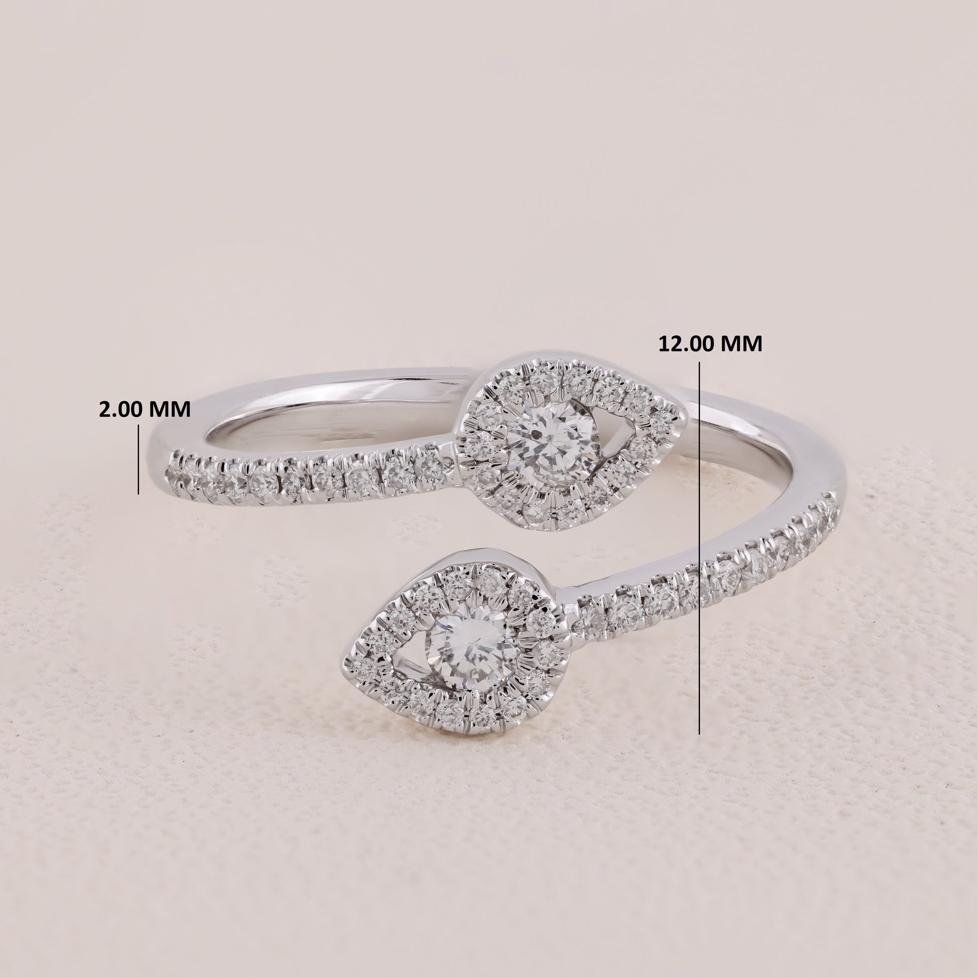 Silver ring with diamond accents and measurements on a beige background