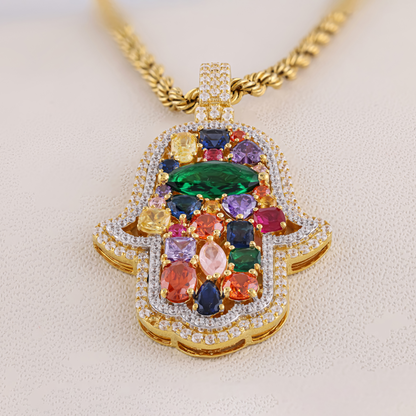 Multicolored gemstone pendant on a gold chain against a beige background