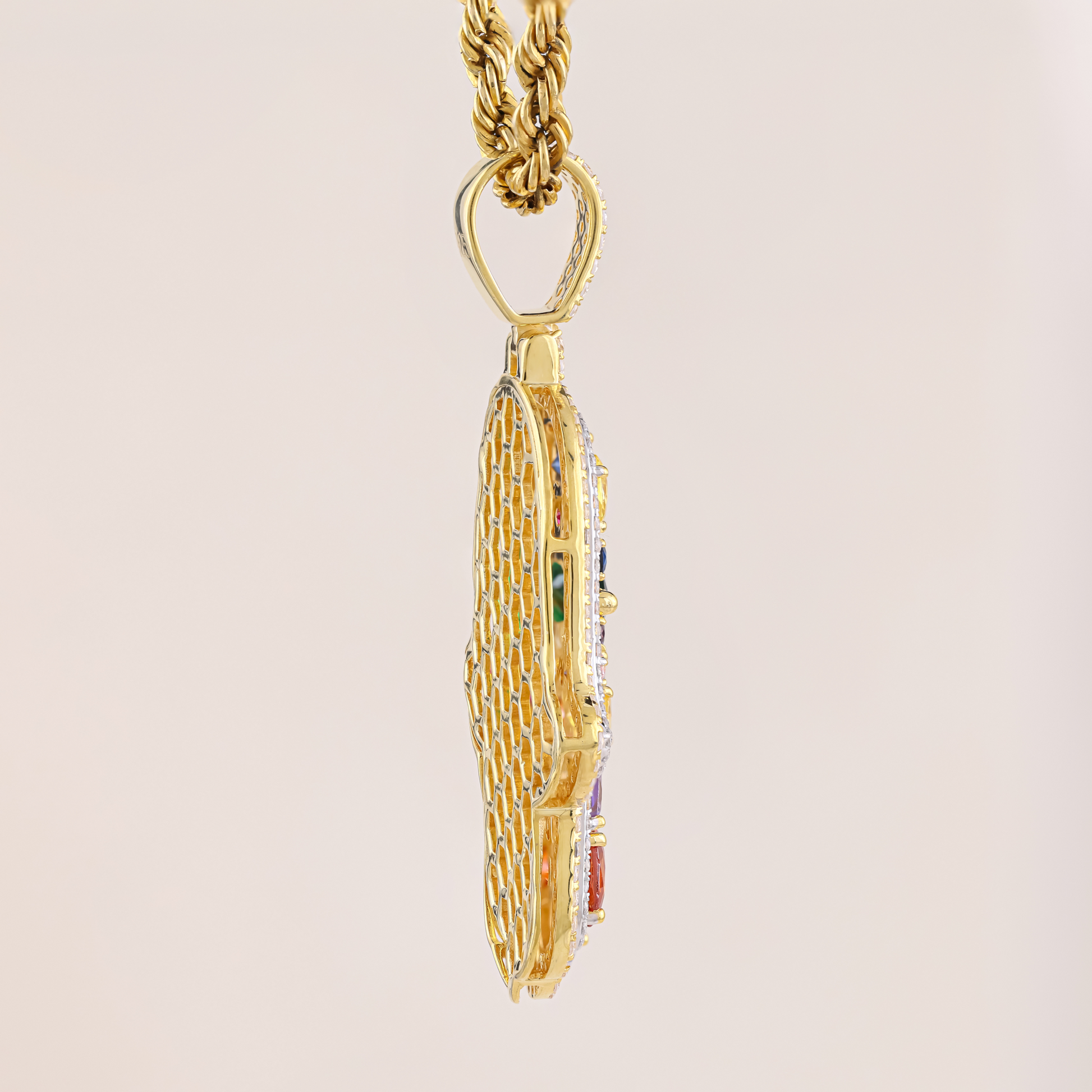 Gold necklace with a detailed pendant on a beige background