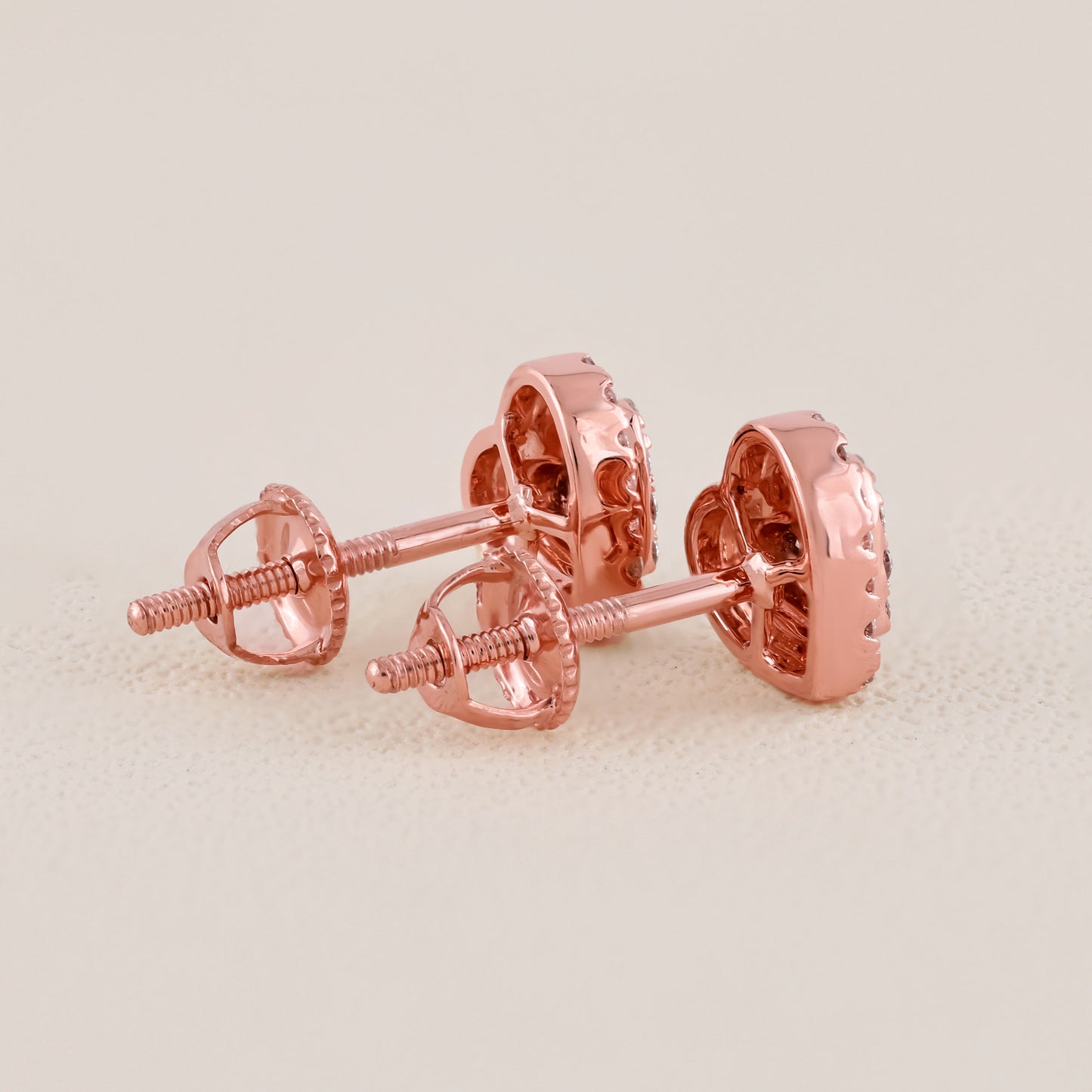 Rose gold earrings on a light beige background