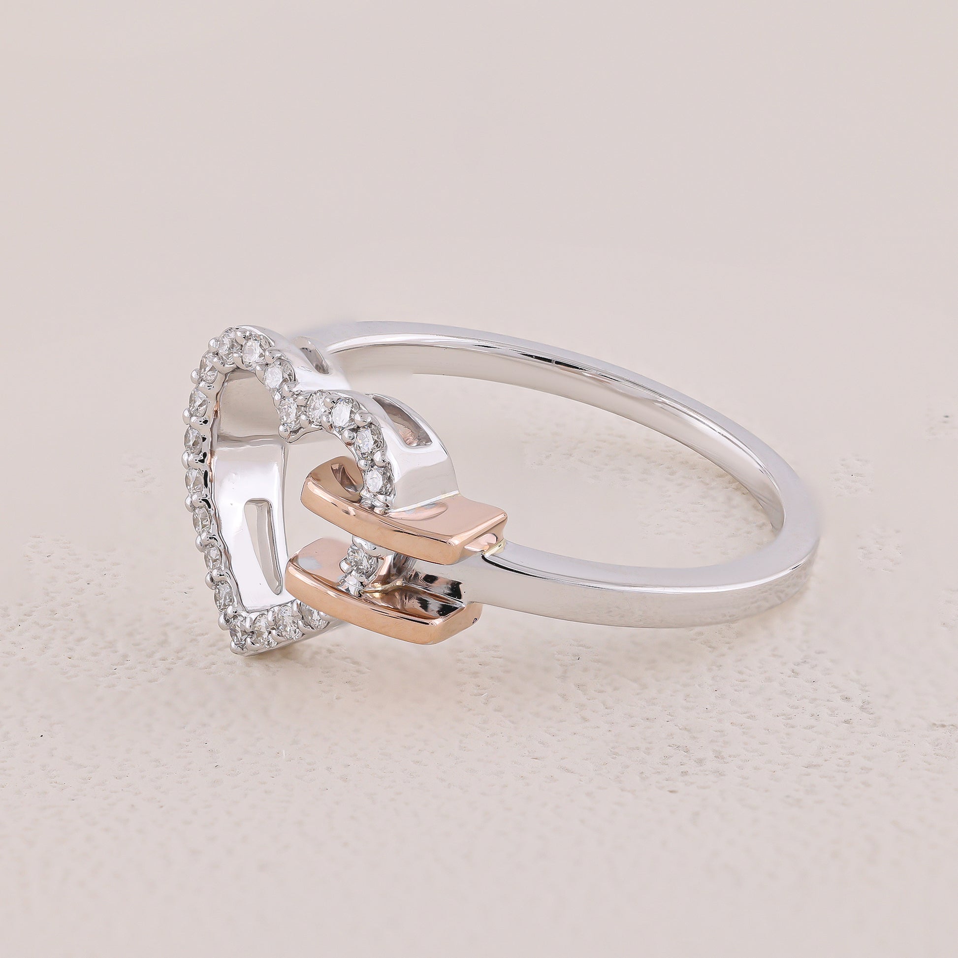 Silver ring with rose gold accents on a light beige background