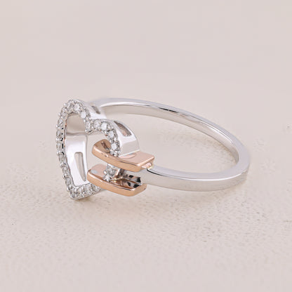 Silver ring with rose gold accents on a light beige background