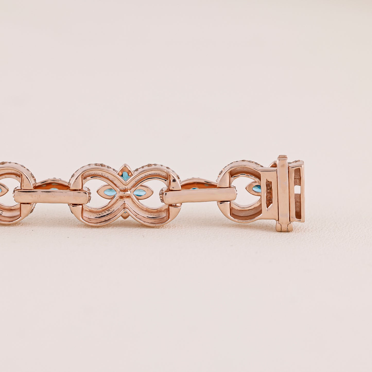 Rose gold bracelet with turquoise stones on a beige background