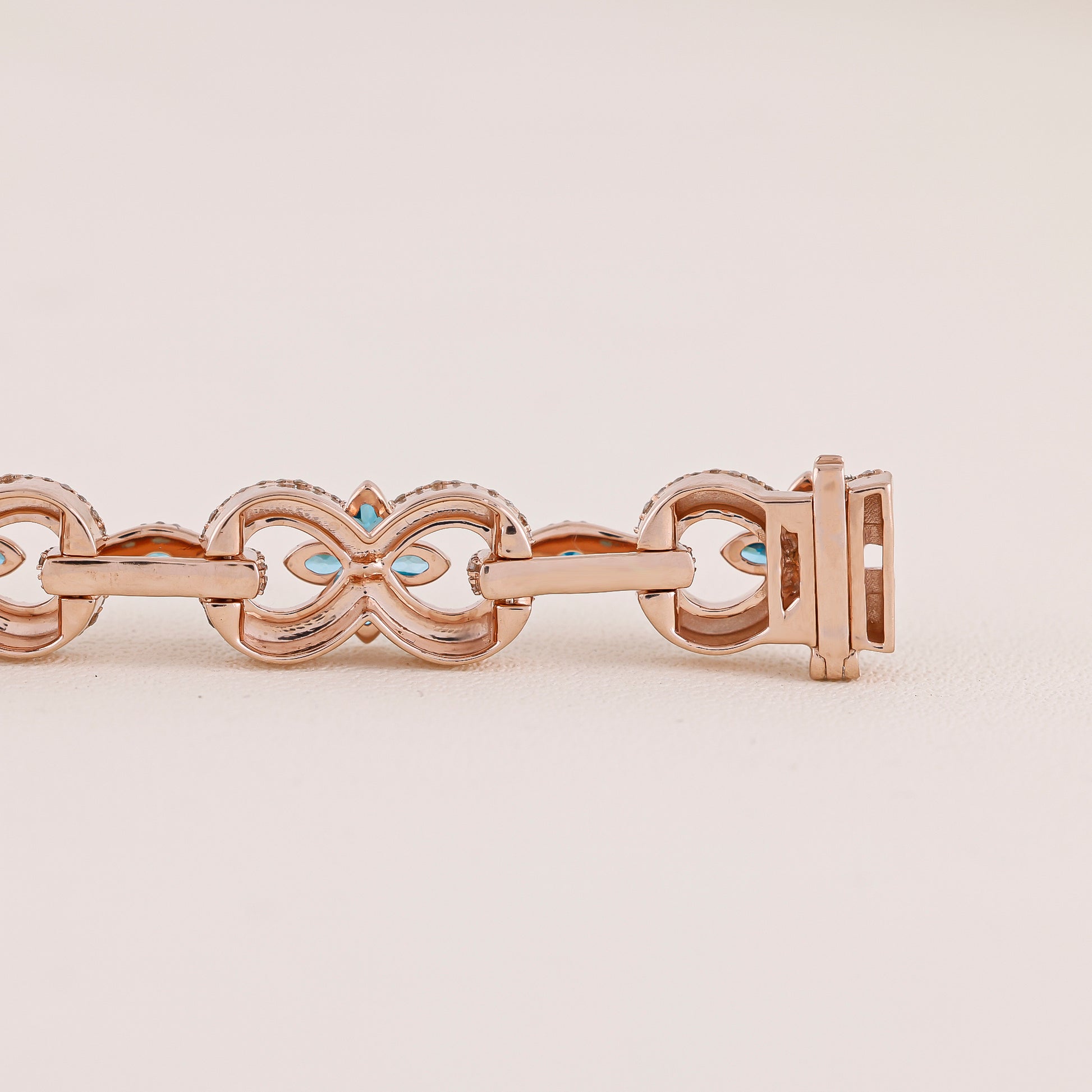 Rose gold bracelet with turquoise stones on a beige background